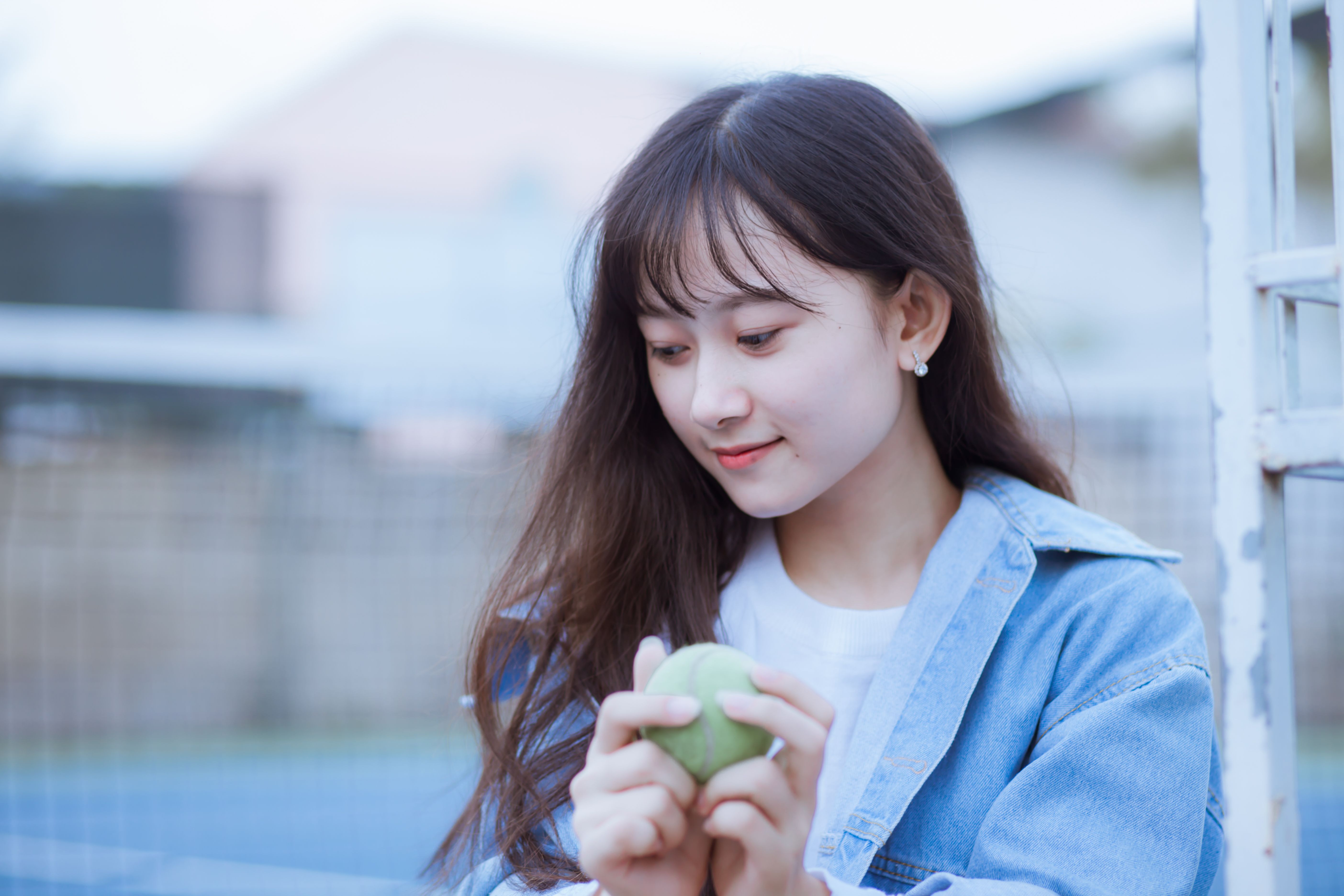 Young woman holding a tennis ball outdoors