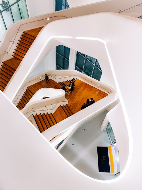Free A stunning perspective of a modern architectural staircase with people in a bright interior. Stock Photo