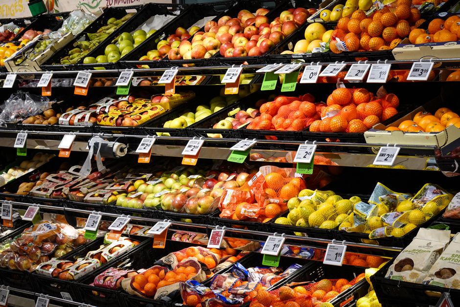 Colorful assortment of fresh fruits neatly arranged on supermarket shelves, ideal for healthy eating themes.
