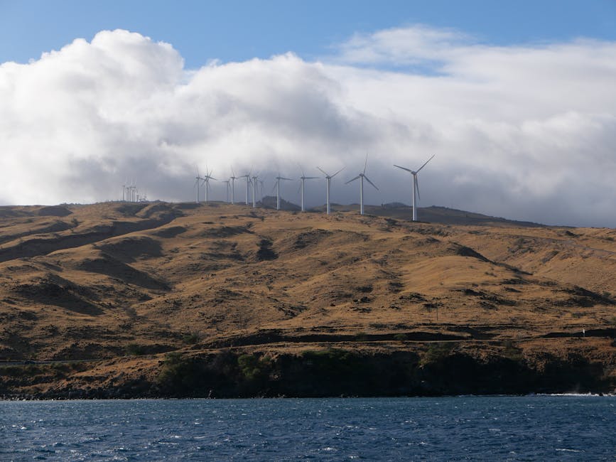 Photo by Larry Hyler Scenic view of wind turbines on a hillside in Maui, Hawaii, under cloudy skies.