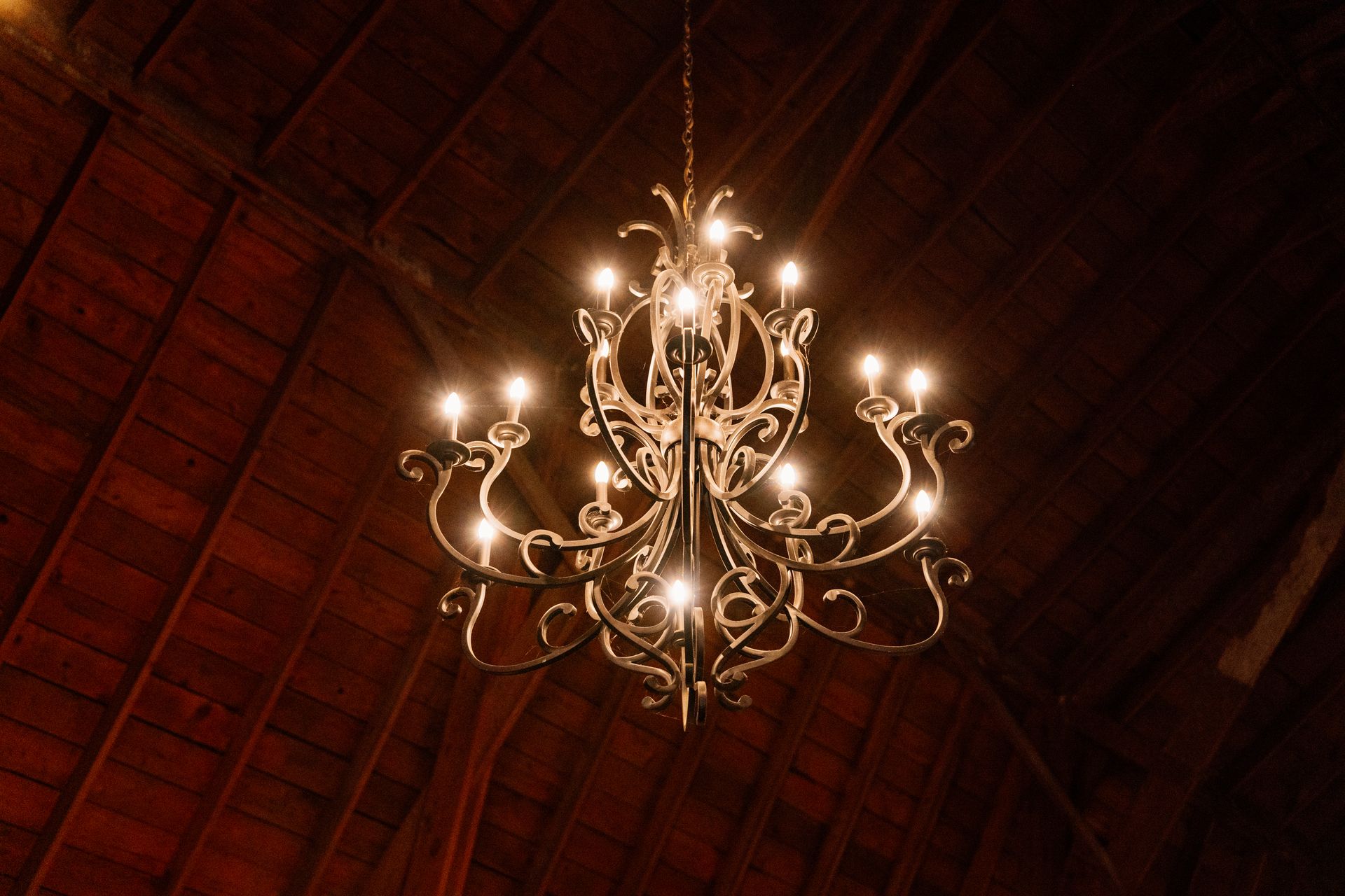 Elegant chandelier hanging from a wooden barn ceiling in Lake Geneva, Wisconsin.