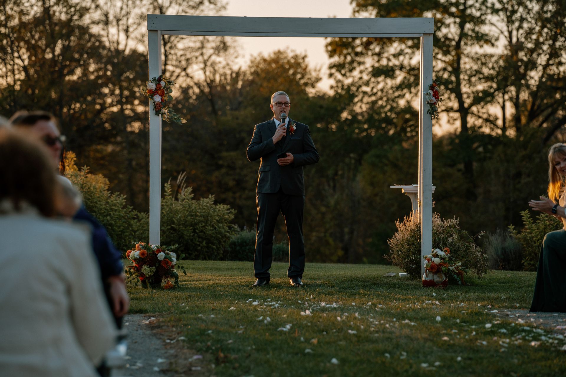 A serene outdoor wedding in Lake Geneva with a speaker at sunset.