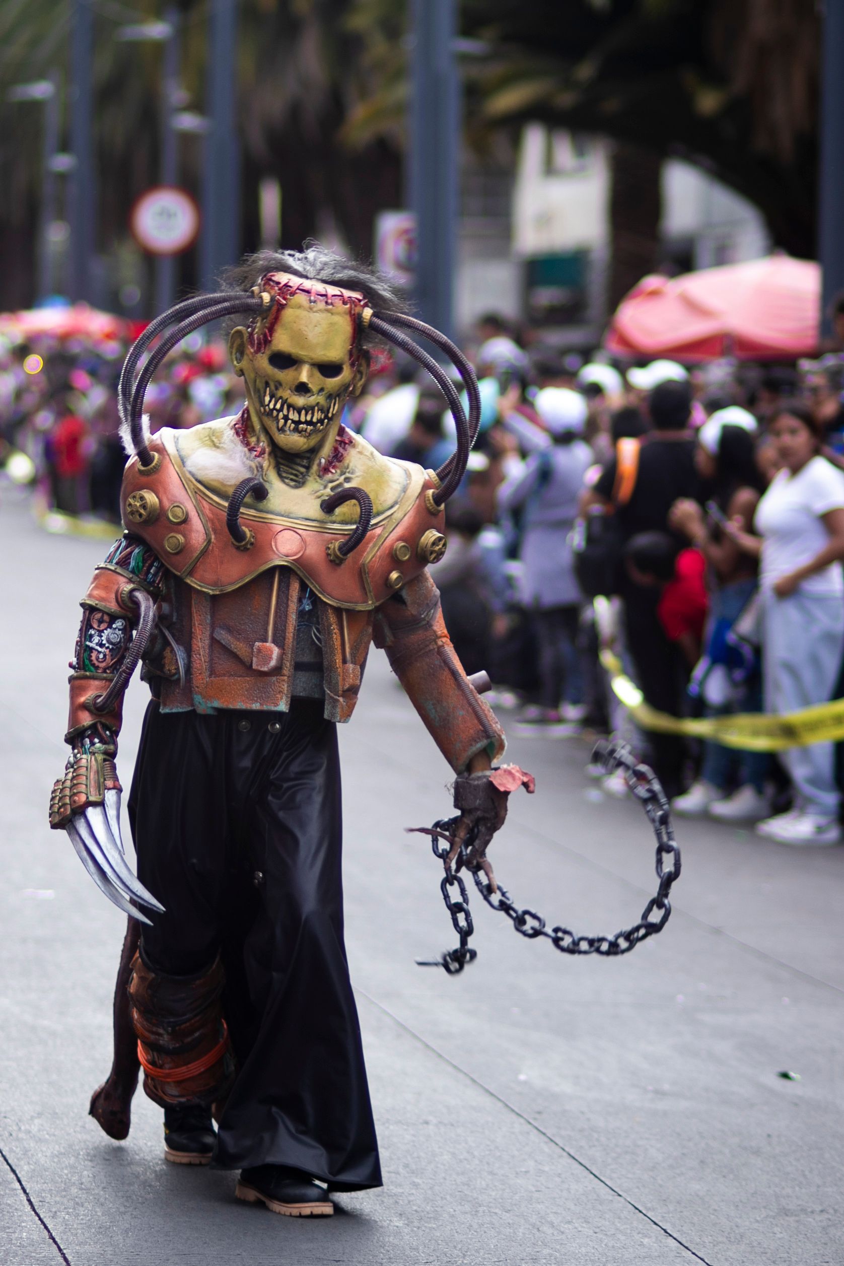 A costumed performer in an elaborate outfit moving down a crowded street during an evening parade