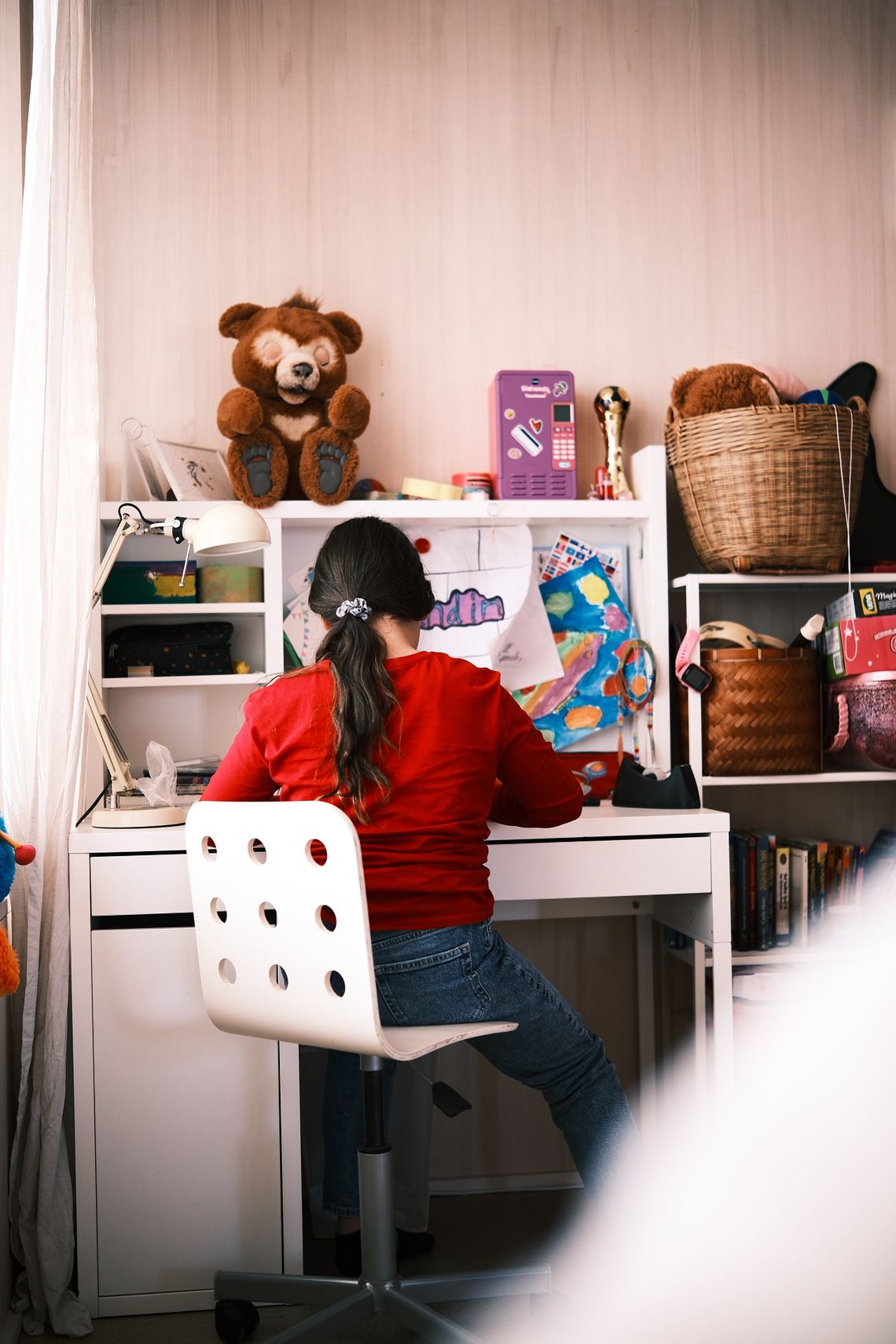 Child studying at an organized learning desk surrounded by books and educational materials
