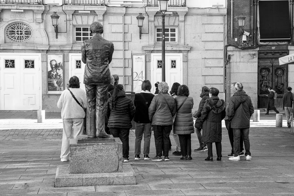 Camarero coordinando platos con menú digital en fachada de restaurante español