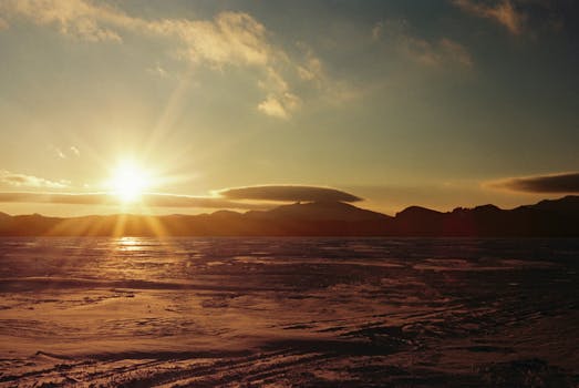 Serene sunrise over a vast frozen lake in Kazakhstan's Akmola region.