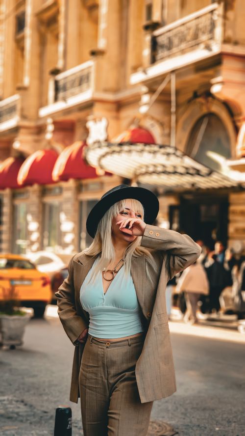 Free Chic woman posing confidently on city street, exuding vintage fashion vibes. Stock Photo