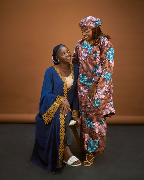 Free Two women smiling and dressed in colorful traditional African clothing. Stock Photo