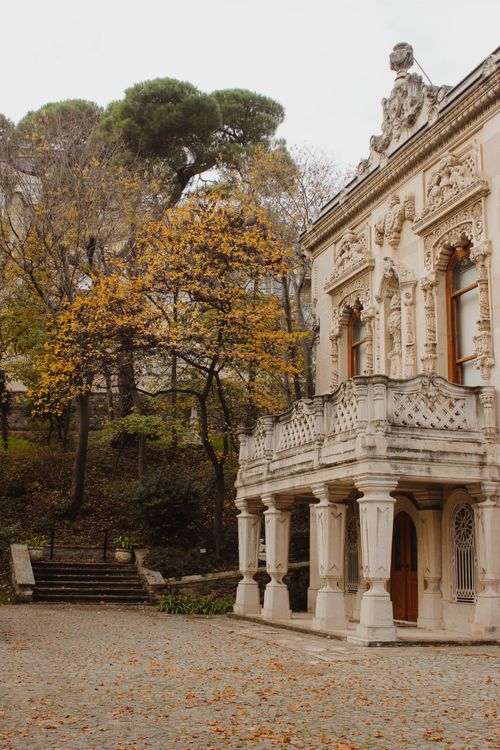 Free Elegant baroque architecture surrounded by fall foliage, offering a picturesque historical scene. Stock Photo