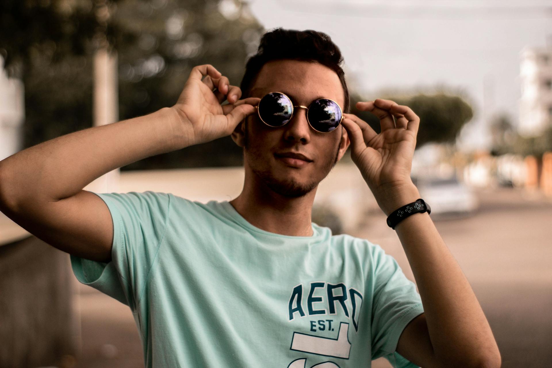 Casual young man posing confidently with sunglasses outdoors in San Pedro De Macorís.