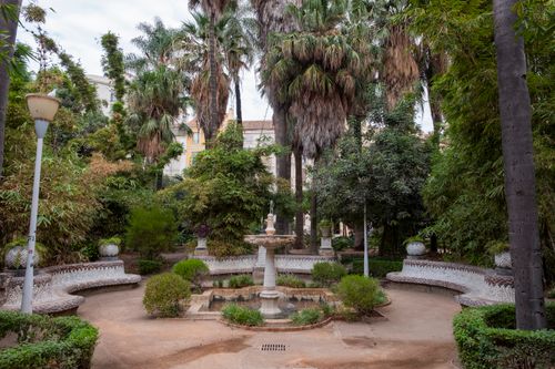 Free Tranquil garden scene with palm trees and fountain in Málaga, Spain's Andalusian charm. Stock Photo