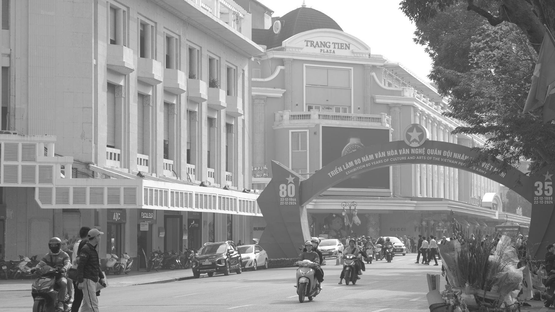 Black and white image of a busy street scene in front of Trang Tien Plaza.