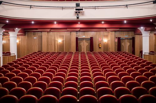 Free An empty theater with red seats and elegant wooden walls. Stock Photo