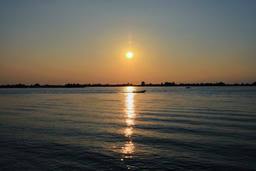 Free Tranquil sunset view over Lake in Venetien, Italy with boats on the water. Stock Photo