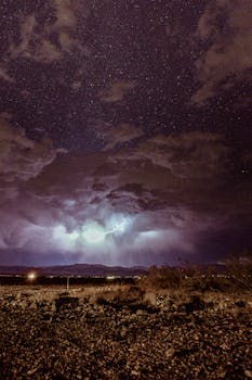 这张夜间图像令人惊叹，它捕捉到了星空下的雷暴，展现了沙漠景观上戏剧性的闪电和云层形成