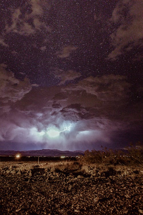 Brown Field Under Cloudy Sky at Night