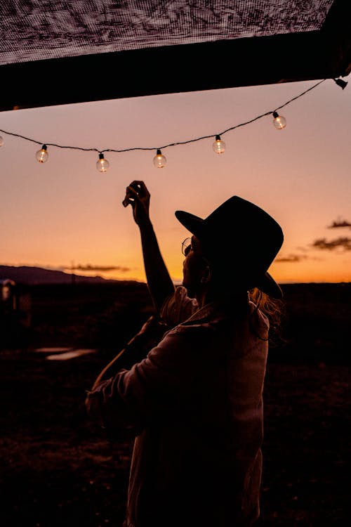 Woman About To Touch String Lights