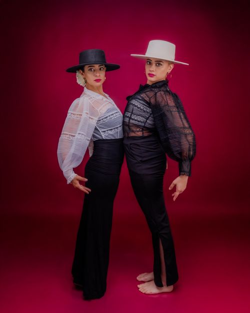 Free Two flamenco dancers striking a pose with vibrant red background, showcasing traditional culture. Stock Photo