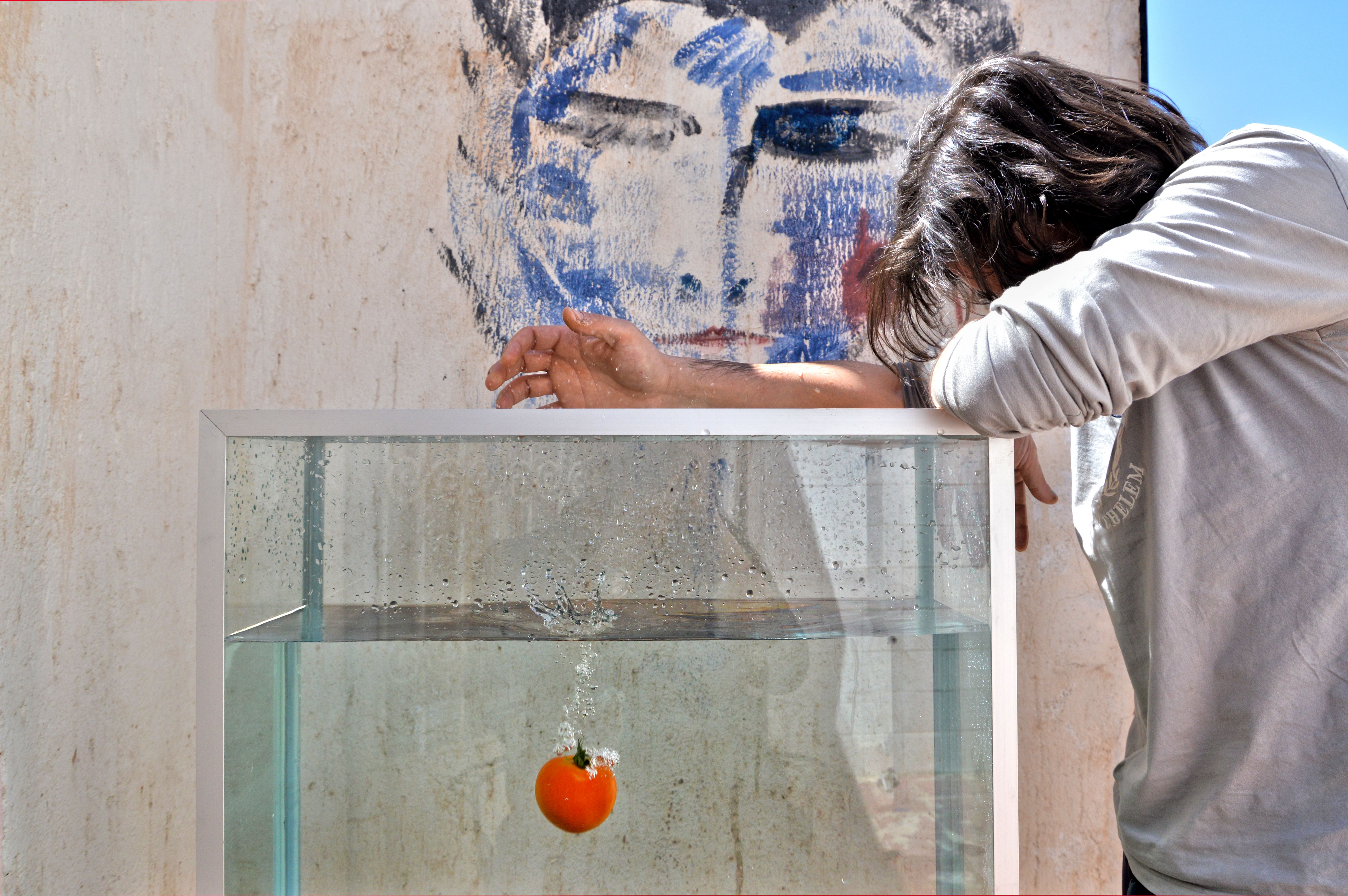 A creative depiction of a tomato splash in water with artistic graffiti background and contemplative