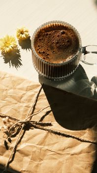 A cozy scene with coffee, flowers, and a wrapped gift creating a warm ambiance.