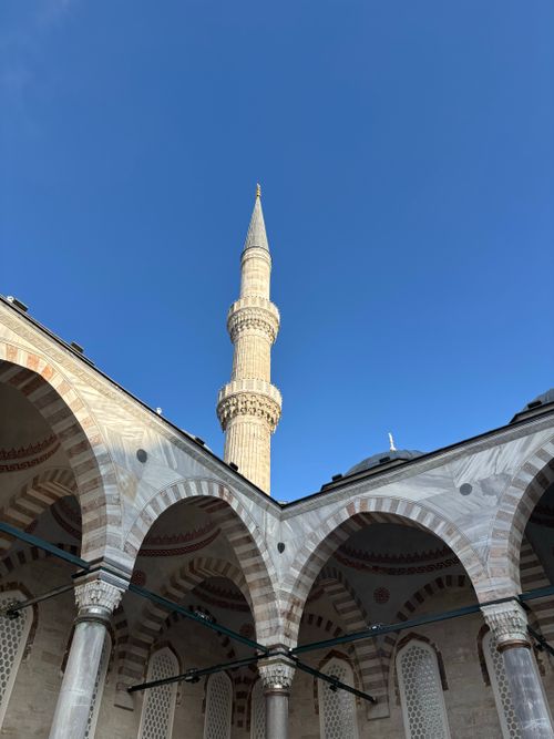 Free A stunning minaret rises against a clear blue sky in an architectural courtyard. Stock Photo