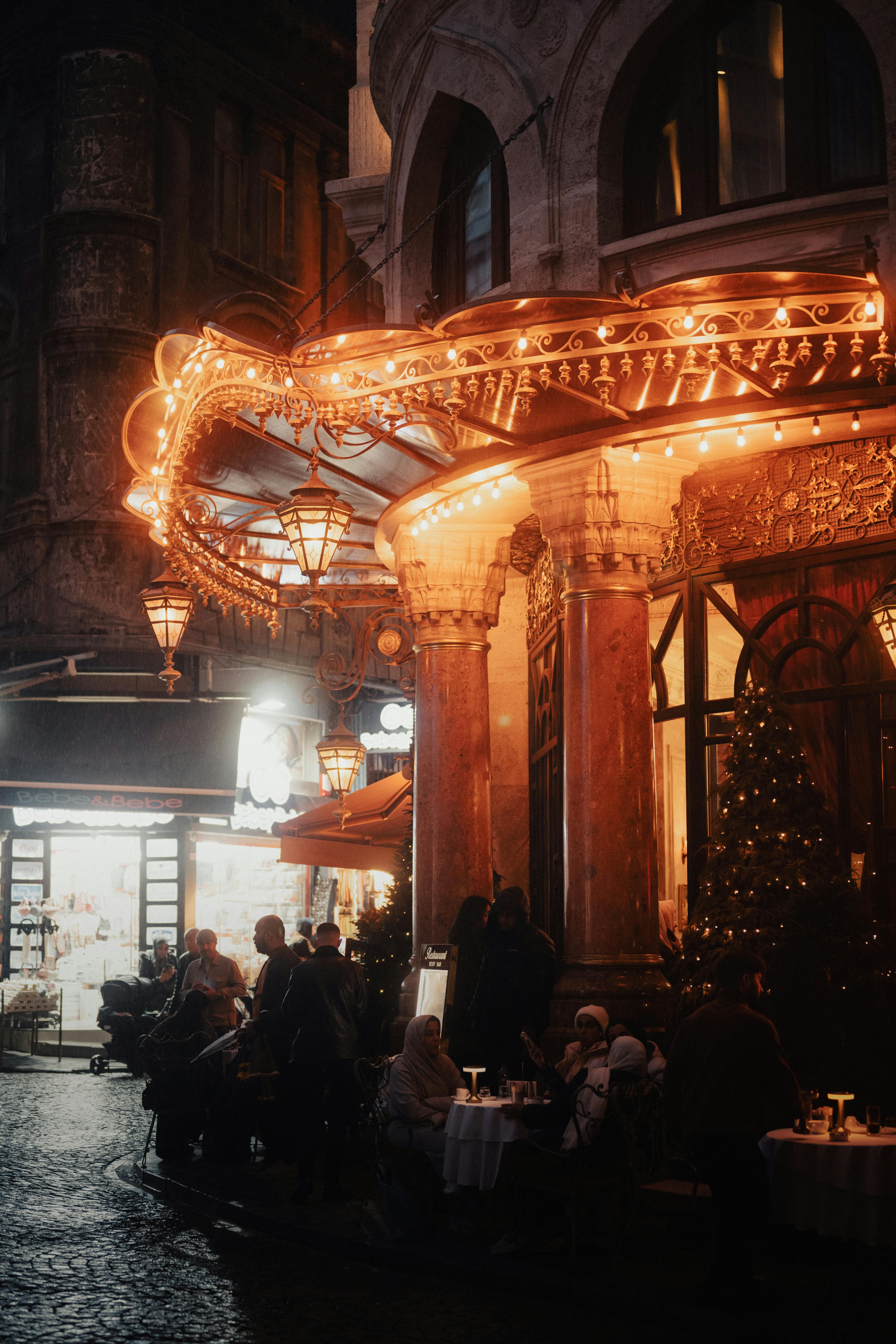 A cozy Istanbul street scene at night, featuring warm lights and lively cafe ambiance.