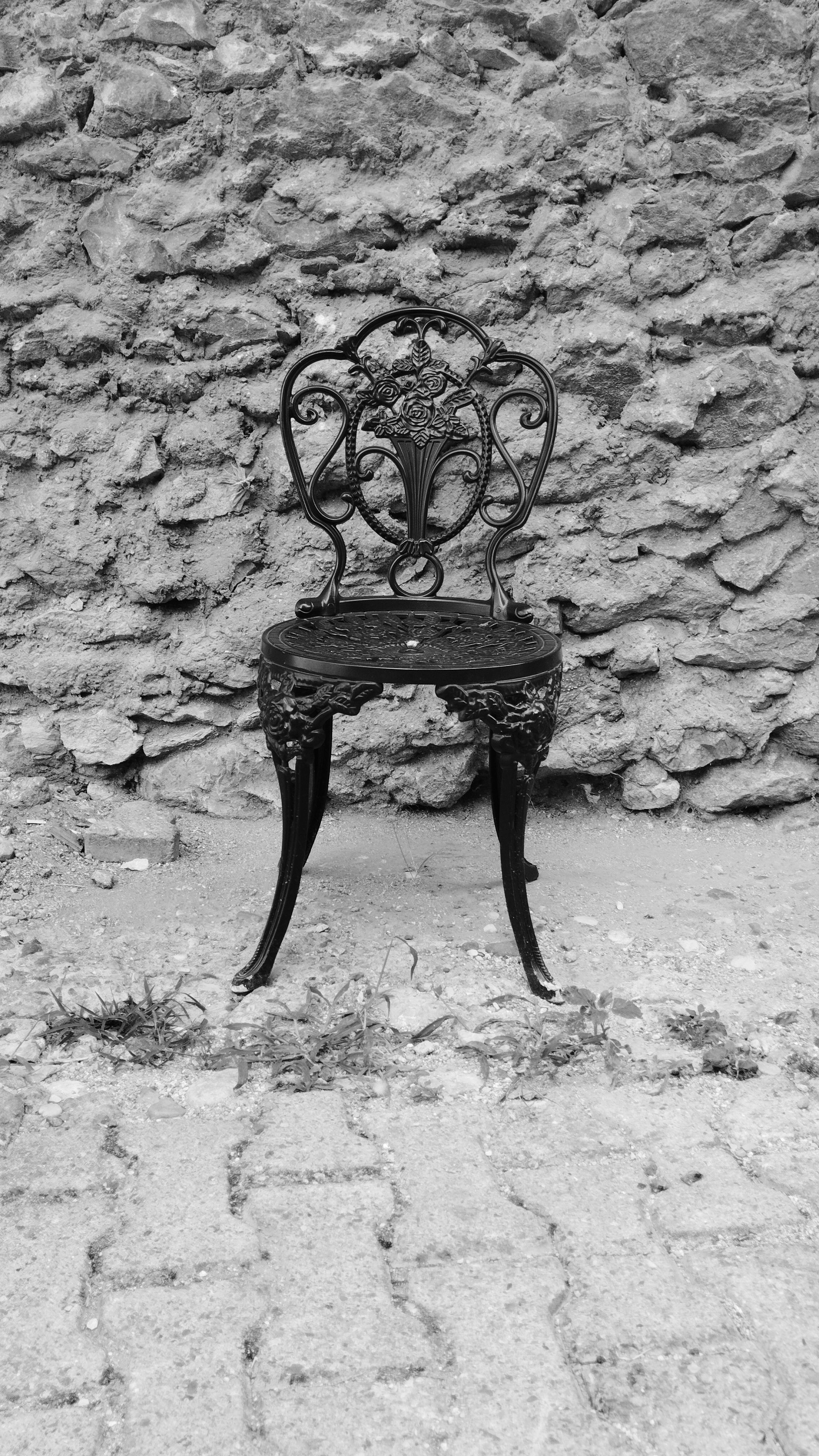 Vintage Ornate Chair Against Rustic Stone Wall · Free Stock Photo