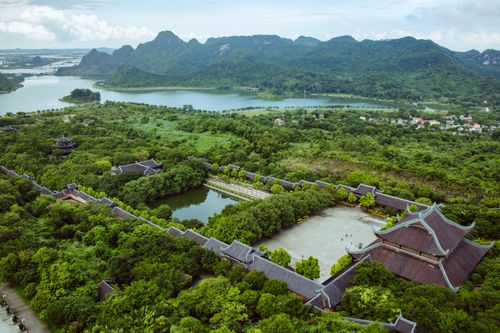 Free Scenic aerial shot of Bai Dinh Temple in Vietnam surrounded by lush greenery and mountains. Stock Photo