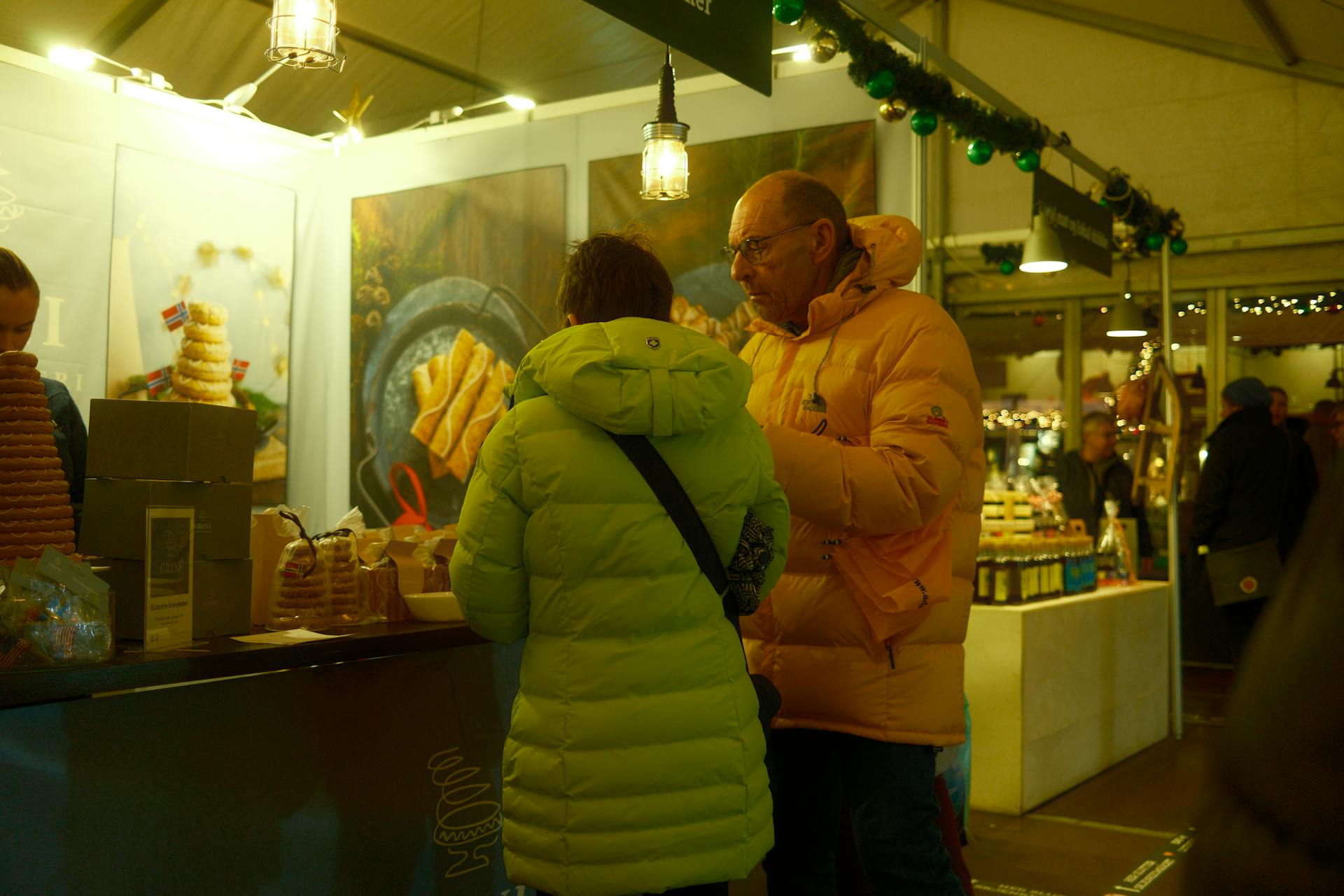 Warm winter scene at a marketplace stall in Bergen featuring Norwegian treats.