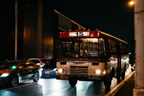 Free A bustling urban street at night with a public transport bus and traffic in an Asian city. Stock Photo