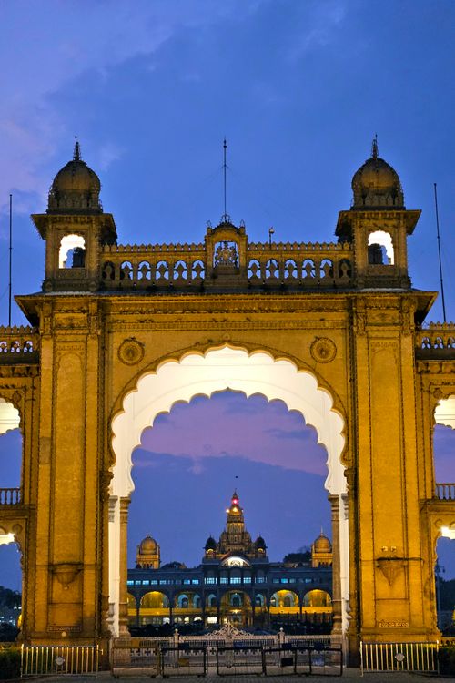 Free Beautiful view of the Mysore Palace through a decorative gate at dusk, highlighting its grandeur. Stock Photo