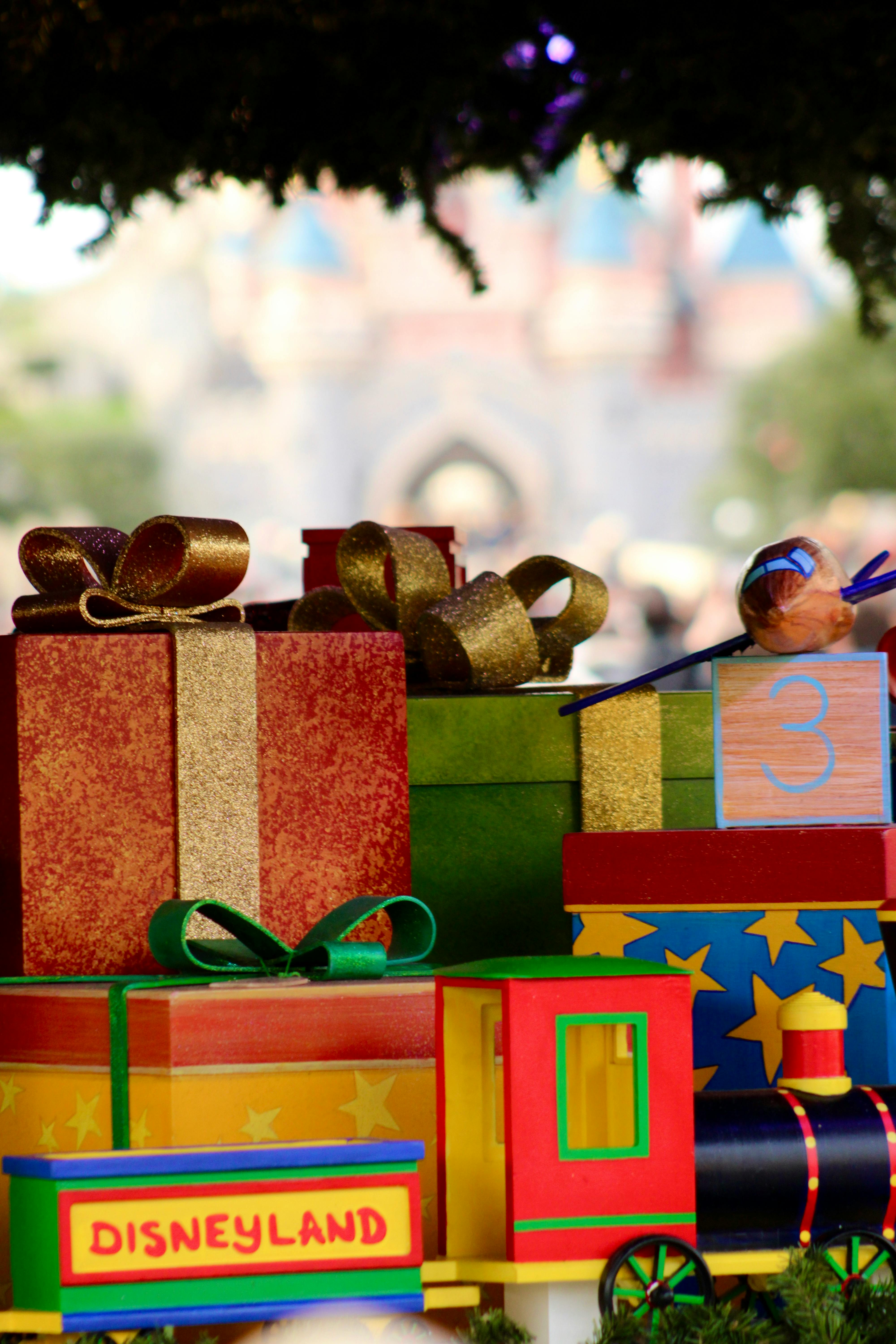 Free Vibrant gift boxes and toy train evoke a festive atmosphere at Disneyland Paris. Stock Photo