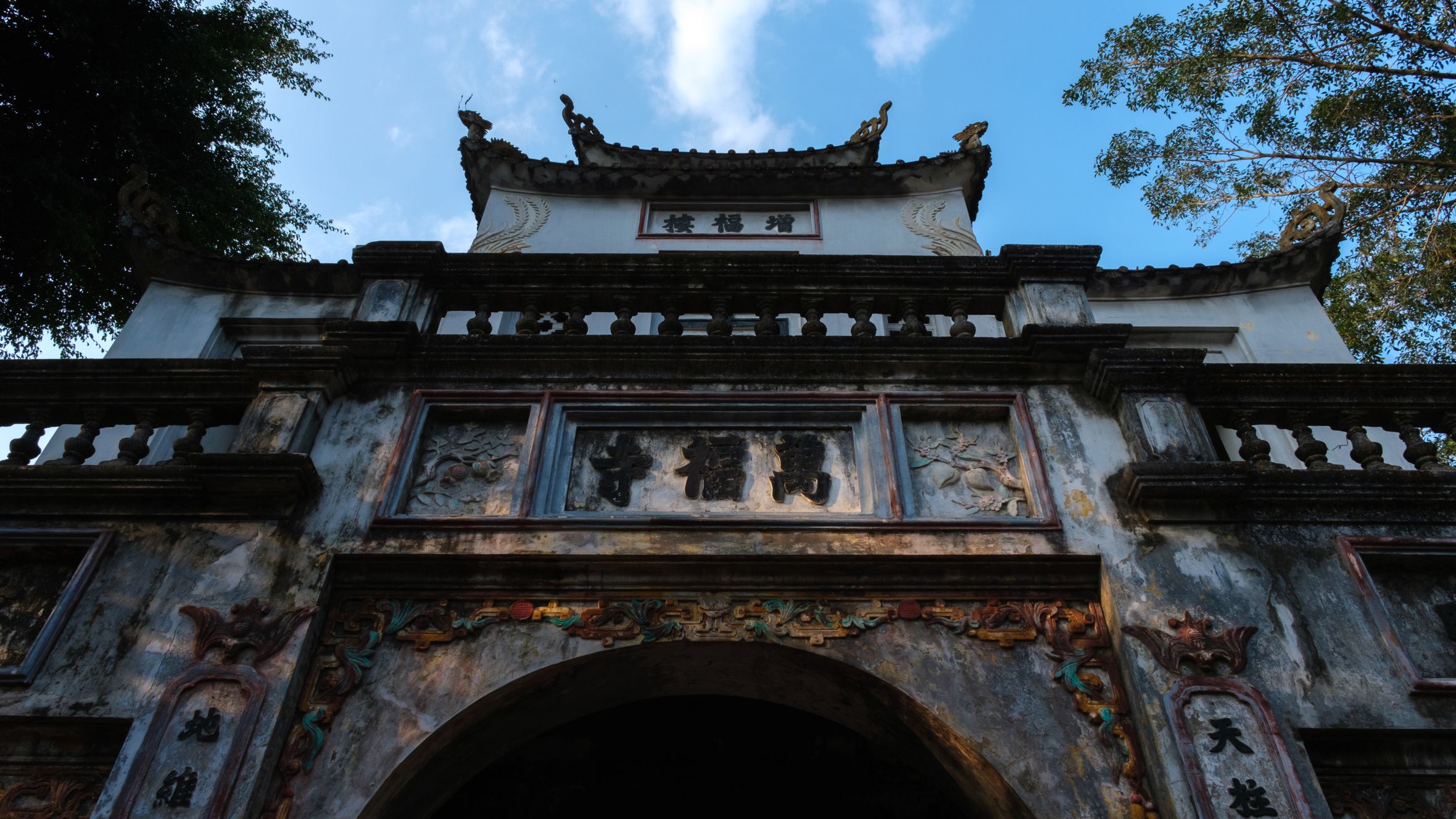 Ancient architectural gate of a temple in Hanoi, showcasing traditional Vietnamese design.