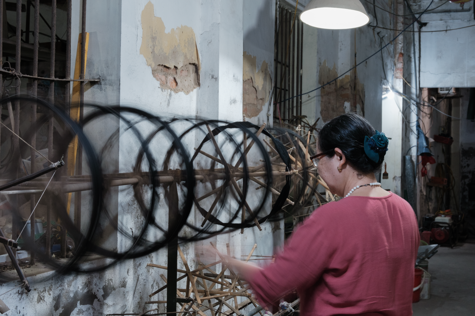 An artisan spins silk threads in a traditional workshop in Hanoi, Vietnam, highlighting cultural heritage.
