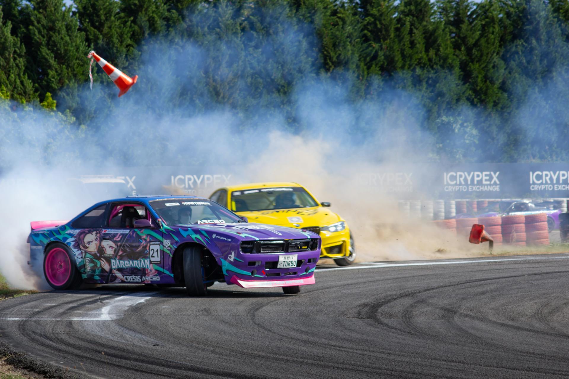 Dynamic drift car race with vivid colors and smoke on a sunny track, showcasing speed and style.