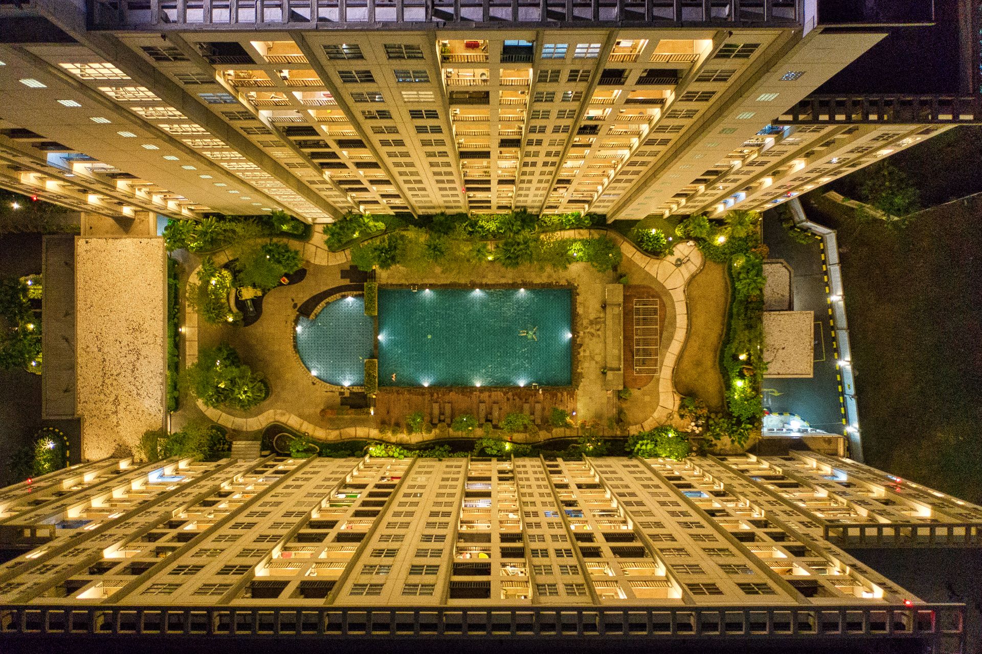 High-angle Photography of Rectangular Green Swimming Pool in Between High-rise Buildings