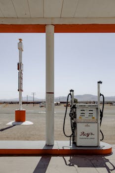 在明亮的日光下，沙漠环境中经典的加油站泵散发着复古魅力