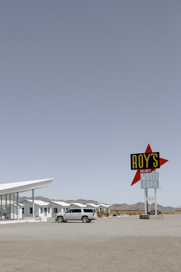 White Car Parked Near Roy's Signage