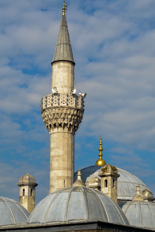 Free A detailed view of a mosque minaret with striking blue sky and clouds in the background. Stock Photo