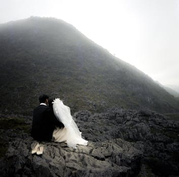A couple embraces on rocky terrain in Hà Giang, Vietnam, creating a romantic wedding moment.