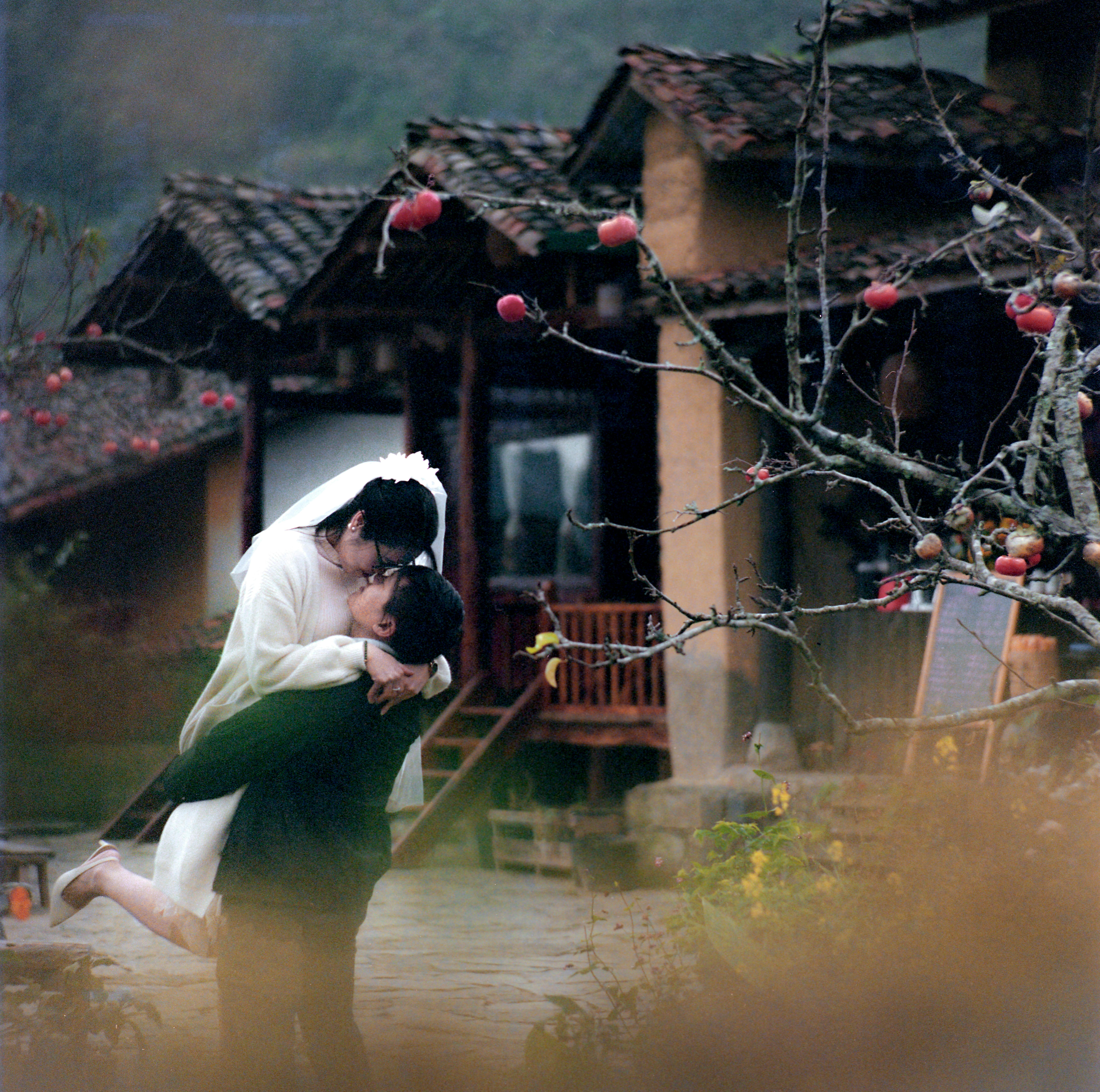 A romantic moment of a couple embraced in a rustic setting in Hà Giang, Vietnam.