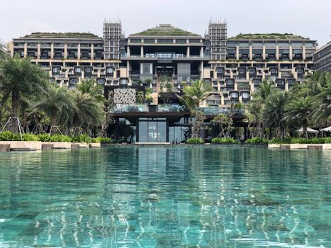 Stunning luxury resort with infinity pool and lush palm trees, perfect for a tropical getaway.