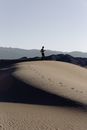 一位独行旅人在日出时分，探索着沙漠沙丘的广阔沙质景观