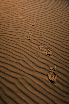 在荡漾的沙丘上，脚印留在干旱的沙漠景观中