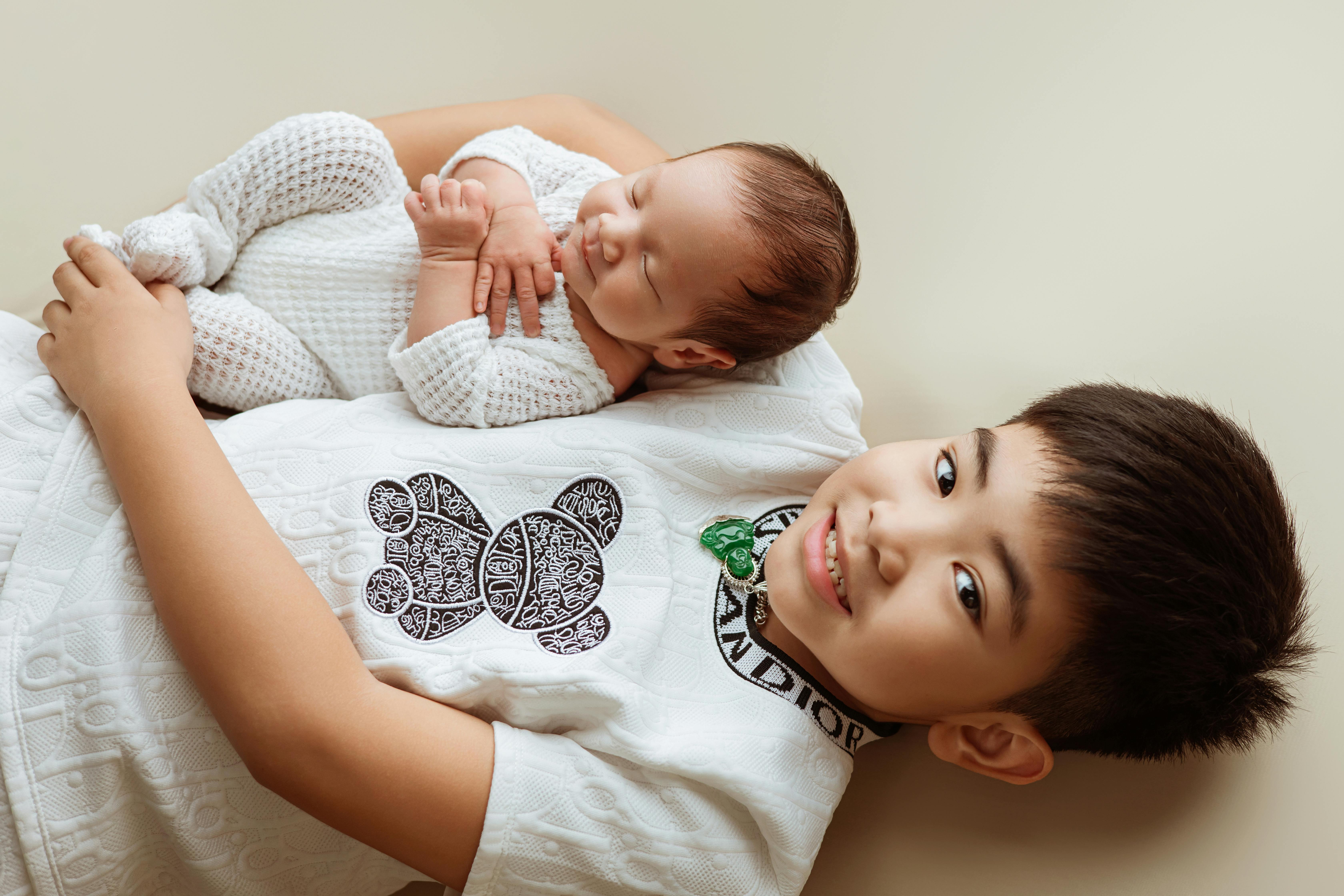 A joyful portrait of a baby and sibling sharing a tender moment in Ho Chi Minh City.