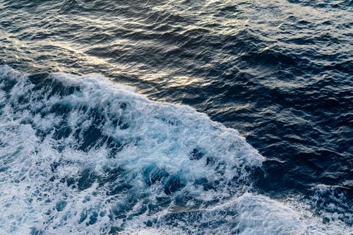 Free Captivating ocean waves with sunlit reflections and textured surface, perfect for nature themes. Stock Photo