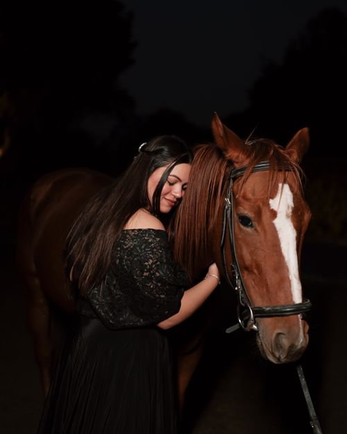 Free A woman dressed elegantly hugs a horse under twilight's gentle light. Stock Photo