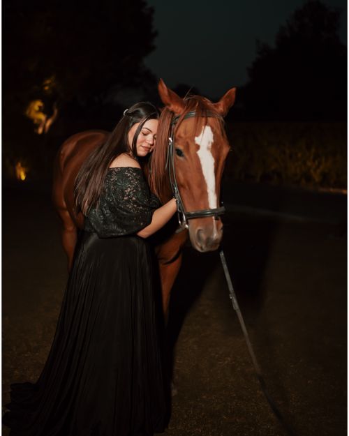 Free Woman posing with a horse at night, conveying elegance and connection. Stock Photo