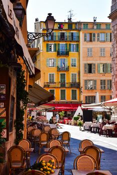Vibrant and charming street view of Nice, France featuring colorful architecture and outdoor cafes.