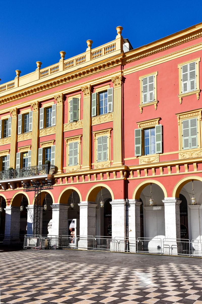 Elegant red arcaded architecture on Place Massena in Nice